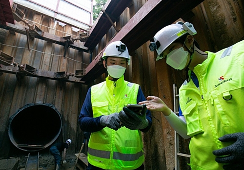 ▲ 작업자가 액션캠과 위치태그 등이 장착된 스마트 안전모를 착용하고 스마트폰으로 현장을 확인하고 있다. 사진제공 = 쌍용건설