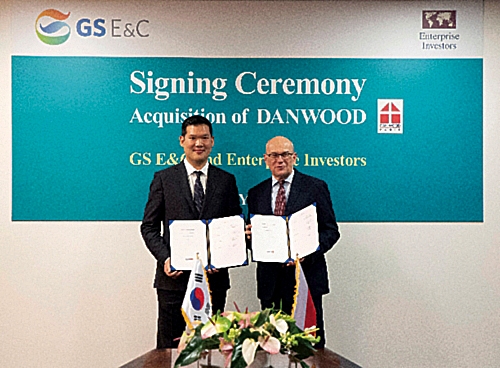 ▲ 허윤홍 GS건설 신사업부문 대표 사장이 지난해 폴란드 단우드 본사에서 야첵 스비츠키 단우드 사장과 함께 단우드 인수를 마무리하는 서류에 서명 후 기념촬영하고 있다.