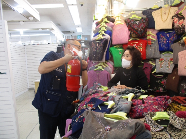 협회 점검요원(사진 왼쪽)이 전통시장 상인에게 소화기 사용법을 설명하고 있다./사진 제공= 화재보험협회