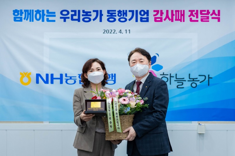 권준학 NH농협은행장(오른쪽)이 지난 11일 고화순 하늘농가 대표(왼쪽)에게 ‘함께하는 우리농가 동행기업’ 선정을 축하하는 감사패와 꽃다발을 전달했다. /사진제공=NH농협은행