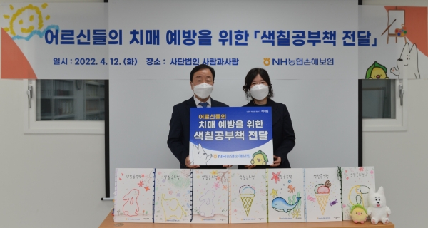 NH농협손해보험은 지난 12일, 서울 양천구 소재 사단법인 ‘사람과사람’을 방문해 치매예방을 위한 ‘색칠공부책’ 200권을 전달했다. 이날 최문섭 대표이사(사진 왼쪽)가 후원물품을 전달한 후 기념사진 촬영을 하고 있다./사진 제공= NH농협손해보험