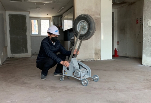 ▲ 삼성물산 직원이 뱅 머신을 이용해 중량충격음 실험을 하고 있다. 사진제공 = 삼성물산