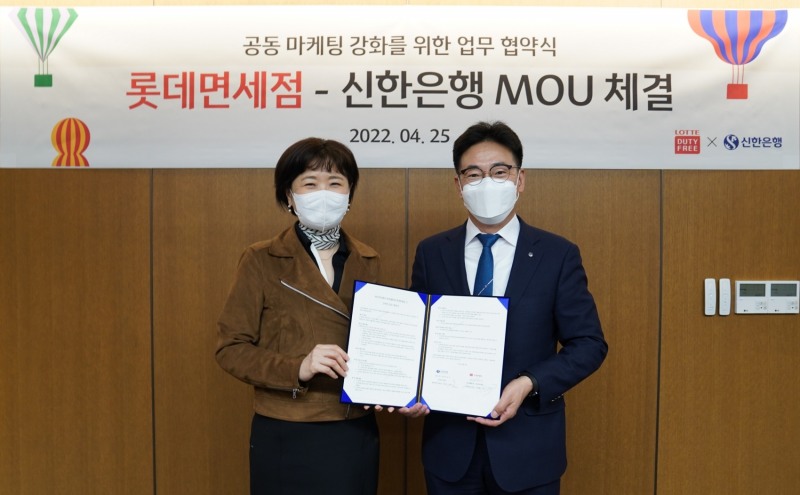 이상진 롯데면세점 마케팅부문장(사진 좌측)과 김민수 신한은행 외환본부장(사진 우측)이 업무협약식 기념 사진을 촬영하고 있는 모습./ 사진제공 = 롯데면세점