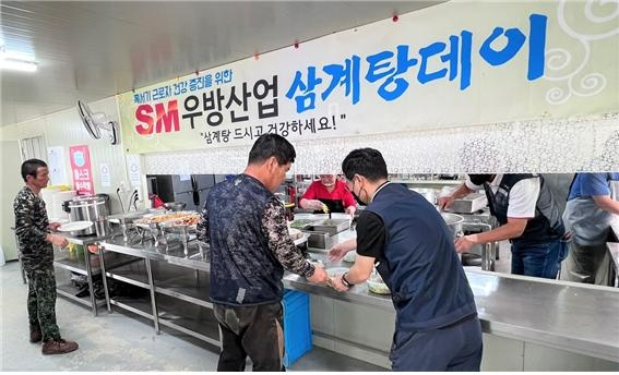 SM우방산업 광주 선교지구 우방아이유쉘 공동주택 신축공사현장에서 근로자에게 혹서기 근로자 건강관리를 위한 삼계탕과 음료를 지급하고 있다. /사진제공=SM우방산업