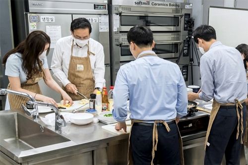 ▲ 손태승 우리금융그룹 회장(왼쪽에서 두 번째)이 지난 7월 1일 그룹사 소속 MZ세대 직원들과 쿠킹클래스 행사에 참여해 요리를 만들고 있다. 사진 = 우리금융그룹