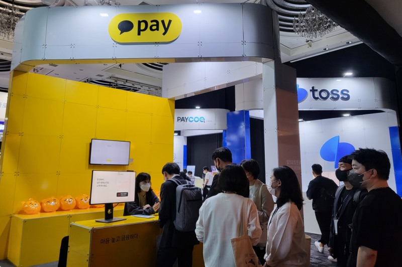 핀테크 체험관 내 카카오페이 부스에서 많은 사람들이 카카오페이 서비스에 대해 설명을 듣고 있다.