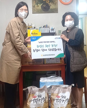 ▲ 농협자산관리회사 서울서부지사는 ‘농업인 신용회복 컨설팅’ 사업을 통해 신용을회복한 A씨(오른쪽)에게 생필품을 전달하고 있다.