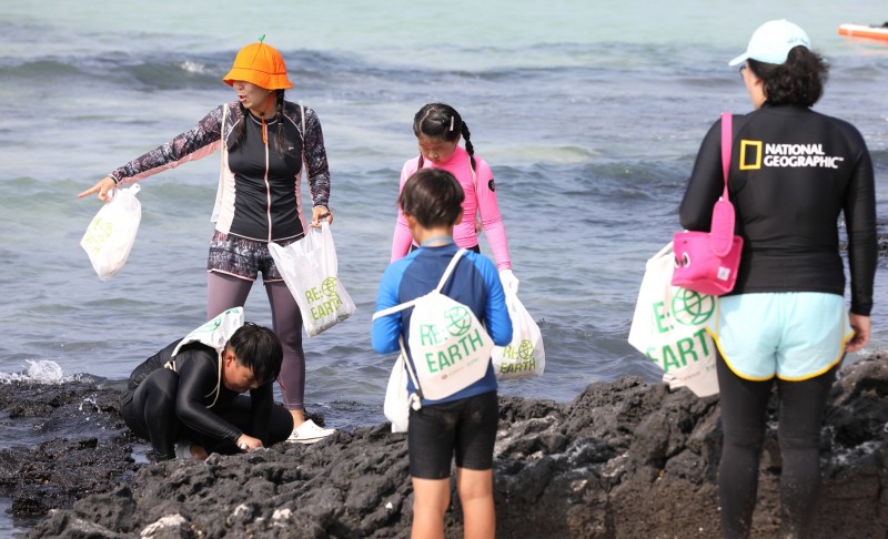 제주 월정리 해수욕장에서 고객들이 리얼스 비치코밍 캠페인에 참여하고 있는 모습./ 사진제공 = 롯데쇼핑