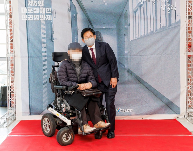박강수 마포구청장(오른쪽)이 장애인 인권 증진을 위해 열린 제5회 마포장애인 인권영화제를 찾은 방문객과 소통하는 모습./사진제공=마포구