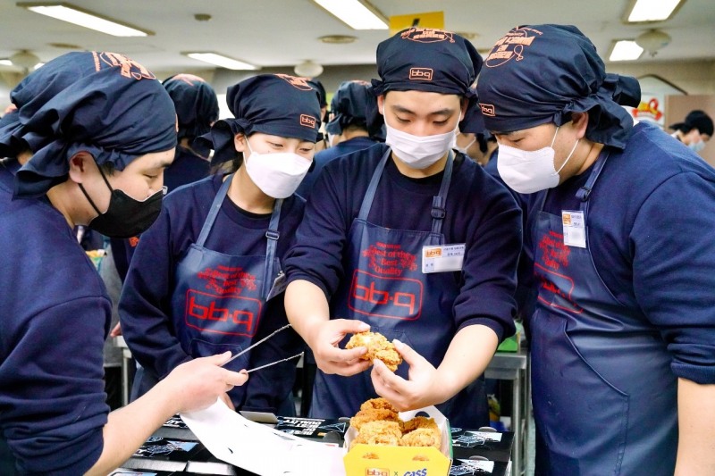 제너시스BBQ 그룹 2023년 신입사원들이 치킨대학에서 제품 오퍼레이션 교육 중에 만든 치킨을 서로 품평하고 있다./ 사진제공 = 제너시스BBQ