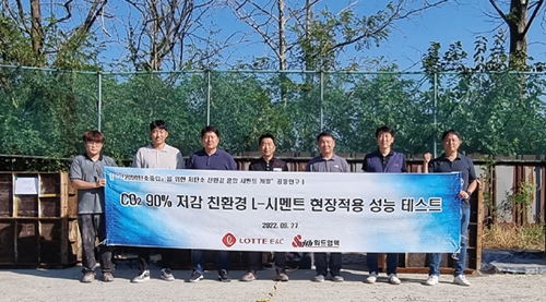 ▲ 롯데건설 기술연구원과 위드엠텍 관계자들이 친환경 콘크리트 개발 성능 테스트 후 사진 촬영을 하고 있다. 사진제공 = 롯데건설