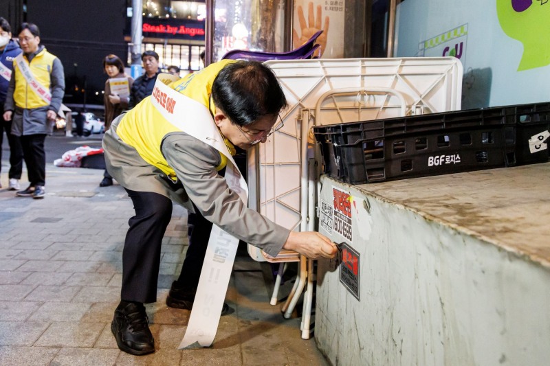 박강수 마포구청장 벽면에 부착된 셔츠룸 스티커를 제거하는 모습./사진제공=마포구