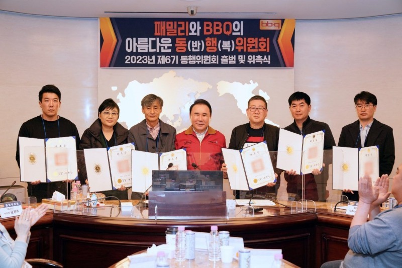 제너시스BBQ 윤홍근 회장(가운데)이 동행위원회 6기 발대식에서 새로 위촉한 패밀리에게 동행위원 위촉패를 전달했다./ 사진제공 = 제너시스BBQ