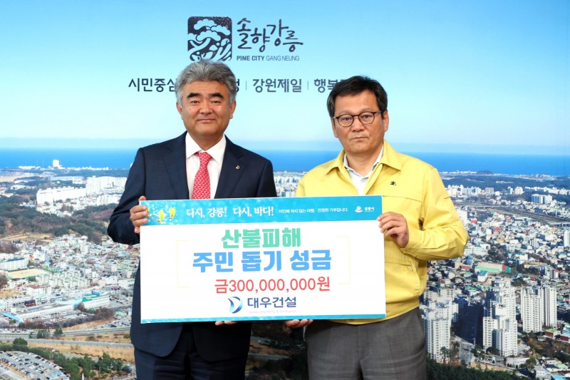 정원주 중흥그룹 부회장(왼쪽)과 김홍규 강릉시장(오른쪽)이 성금 전달 후 기념촬영을 하고 있다. / 사진제공=대우건설