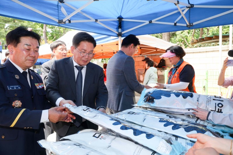 박강수 마포구청장(가운데)이 마포의용소방대 나눔 바자회에 참석해 판매 물품들을 구경하고 있다./사진제공=마포구