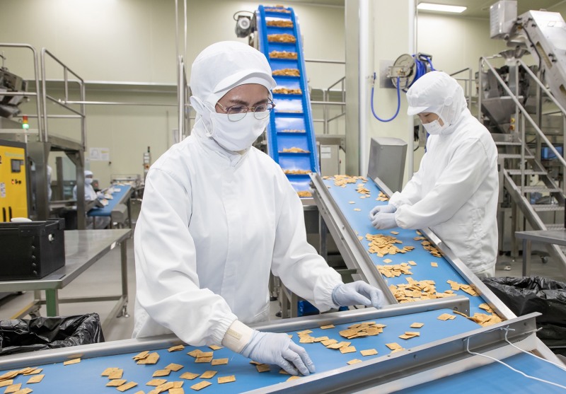 전라남도 여수에 위치한 식품기업 '쿠키아'에서 삼성전자 스마트공장 담당자(오른쪽)과 쿠키아 직원이 두부과자 품질 상태를 점검하고 있다. 사진 제공=삼성전자