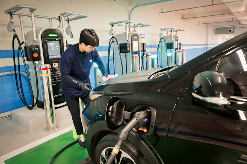 인스타워시 소속 세차전문가가 충전 중인 전기차를 워터리스 방식으로 세차하고 있다. 사진 제공=메리츠화재