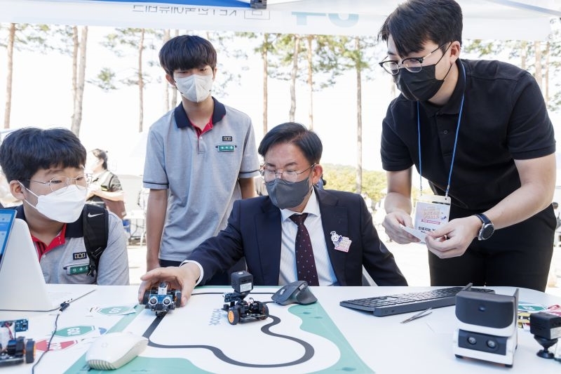 박강수 마포구청장(가운데)이 지난해 개최된 마포진로박람회에서 학생들과 로봇코딩체험을 하고 있다./사진제공=마포구