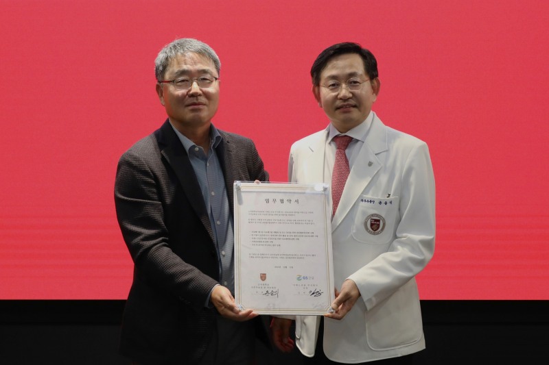 GS건설 경영지원본부장 김태진 사장(왼쪽)과 고려대학교의료원 윤을식 의무부총장이 폐안전모를 재활용한 업무협약패를 들고 기념사진을 촬영하고 있다./사진제공=GS건설