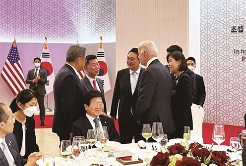 ▲ 윤석열 대통령과 조 바이든 미국 대통령이 지난해 5월 열린 정상회담 공식 만찬 자리에서 김홍국 하림그룹 회장(서 있는 사람 왼쪽에서 두번째)과 얘기를 나누고 있다. 사진 = 축산신문, 독자 제공