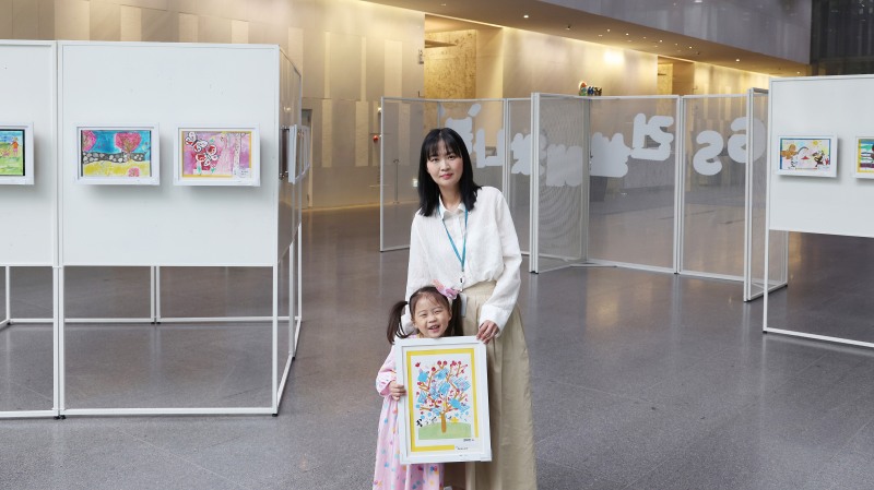 서울 종로구에 위치한 GS건설 본사 사옥 1층에서 진행된 ‘GS건설에 왔나 봄’ 그림전시전에서 임직원이 자녀와 관람하는 모습./사진제공=GS건설