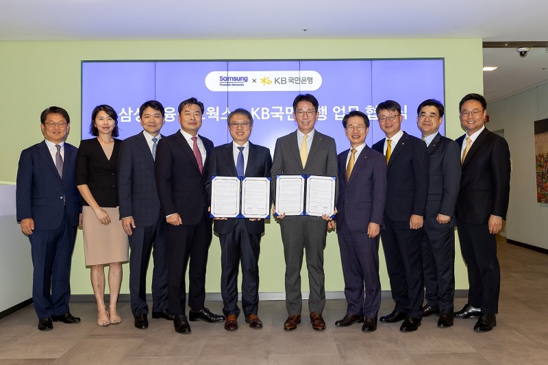 KB국민은행과 삼성금융네트웍스는 지난 4일 서울시 중구 삼성본관에서 상호 협력을 위한 업무협약을 체결했다. 김대환 삼성카드 사장(왼쪽 다섯번째)과 이재근 KB국민은행장(왼쪽 여섯번째), 삼성생명·화재·카드·증권 모니모 관련 업무 담당 임원, KB국민은행 임원 등 관계자들이 기념사진을 촬영하고 있다./사진제공=국민은행