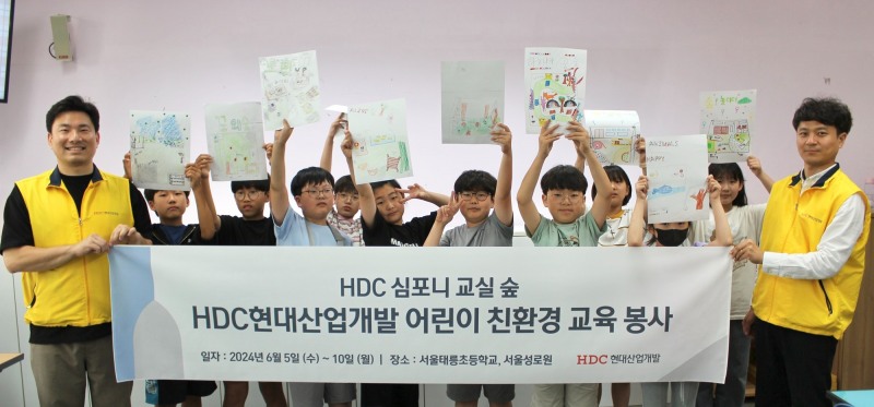 HDC현대산업개발은 지난 5일 심포니 교실 숲 조성 활동의 일환으로 서울시 노원구에 있는 태릉초등학교에서 친환경 교육 봉사를 진행하고 기념촬영을 하는 모습.사진제공=HDC현대산업개발