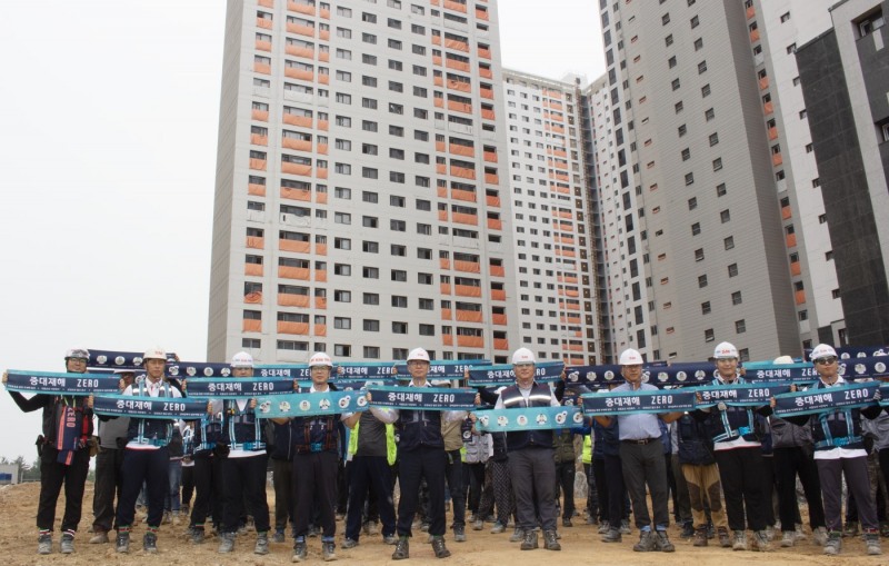 성낙원 SM스틸 건설부문 대표이사(앞줄 왼쪽에서 다섯번째)가 근로자들과 ‘중대재해 ZERO’라고 표기된 타월을 들어 보이며 기념촬영을 하는 모습./사진제공=SM그룹