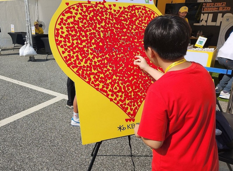지난 달 KB캐피탈 홍보부스를 방문한 어린이가 기부 응원을 위한 하트 스티커 부착 이벤트에 참여하고 있다. / 사진 = KB캐피탈