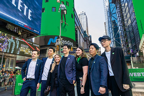 ▲ 지난해 6월 웹툰 엔터테인먼트 나스닥 상장 기념 행사에서 김준구 웹툰 엔터테이먼트 대표(가운데)와 손제호 문피아 대표(왼쪽에서 두번째)가 관계자들과 기념 사진을 촬영하고 있다. 사진 = 네이버웹툰