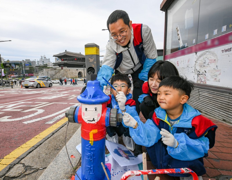 현대모비스 임직원과 가족들이 화재 예방과 시인성 향상을 위해 지상식 소화전에 도색 봉사활동을 실시하고 있는 모습. / 사진=현대모비스