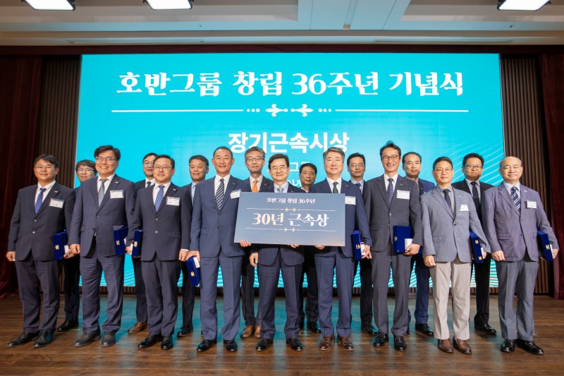 김선규 호반그룹 회장(앞줄 왼쪽에서 다섯 번째)이 창립 36주년 기념식에서 장기 근속자(30년)에게 근속패와 부상을 수여하고 대상자들과 기념촬영을 하는 모습./사진제공=호반그룹
