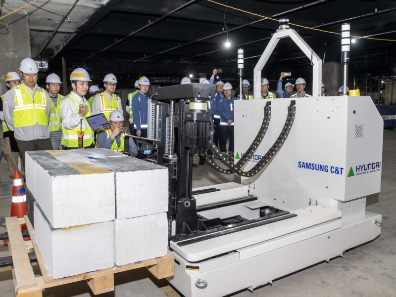 현대건설과 삼성물산이 공동 개발한 ‘스마트 자재 운반 로봇’이 현장에서 자재를 싣고 자율주행 이동하고 있다./사진제공=현대건설