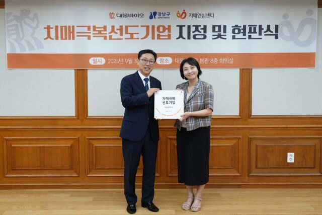 진성곤 대웅바이오 대표(사진 왼쪽)와 박은정 강남구치매안심센터 부센터장이 치매극복선도기업 지정 및 현판식에서 기념촬영을 하고 있다. /사진=대웅바이오