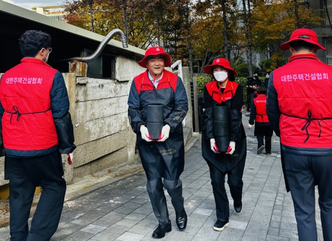 정원주 대한주택건설협회 회장(사진 왼쪽에서 두 번째)과 임직원들이 사랑의 연탄나눔 봉사활동에 구슬땀을 흘리고 있다./자료제공=주건협