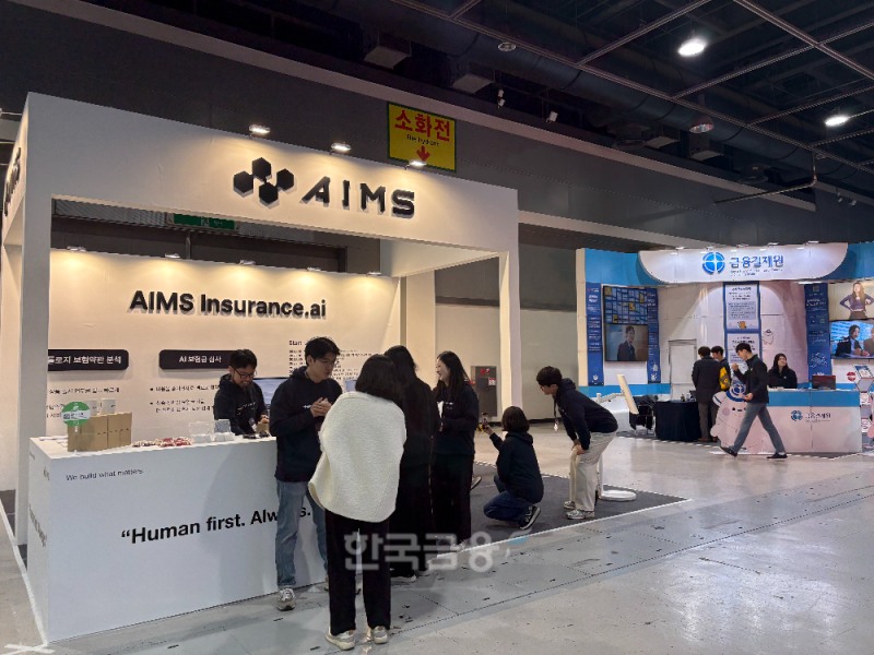 인슈어테크 에임스가 26일 양재 aT센터에서 열린 '코리아 핀테크 위크 2025'에서 부스에 방문한 고객에게 자사 서비스를 설명하고 있다./사진=전하경 기자