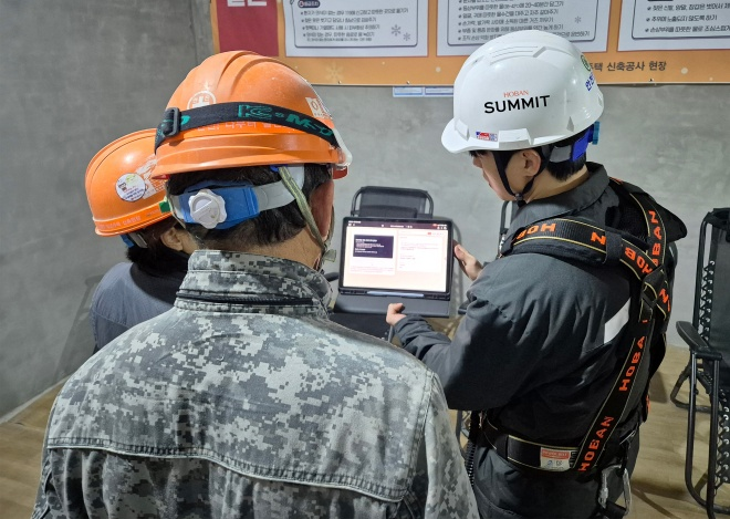 호반건설 직원이 건설 현장에서 AI 동시번역 플랫폼 ‘호반커넥트’를 활용해 근로자들과 대화하고 있다./호반건설