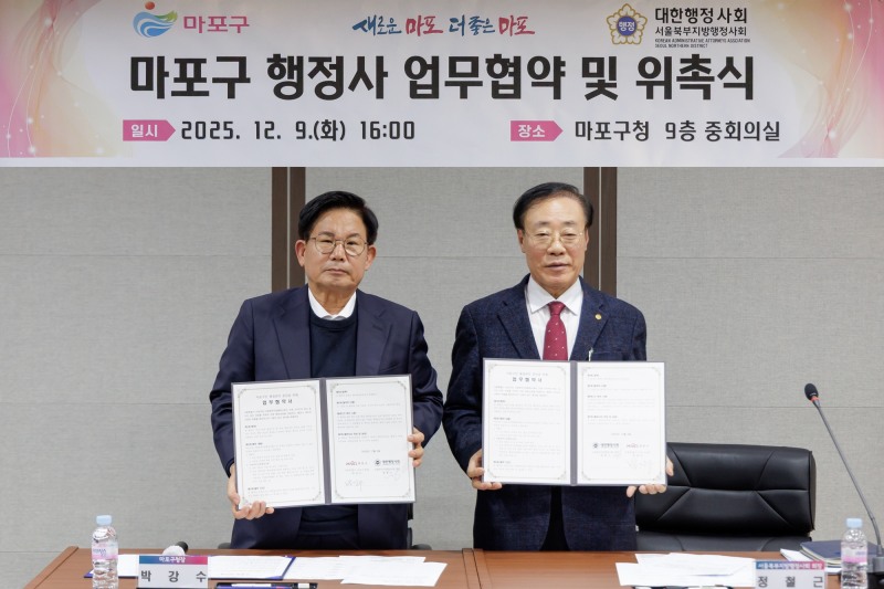 박강수 마포구청장와 정철근 서울북부지방행정사회 회장이 협약을 체결하고 기념촬영을 하는 모습./사진제공=마포구