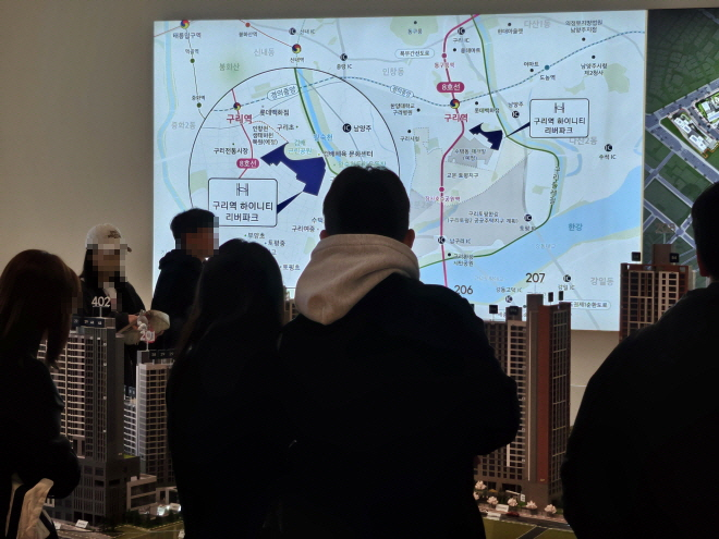 27일 구리역 하이니티 리버파크 견본주택 안의 모형도에서 조감도와 입지를 확인하는 방문객들./한국금융신문 조범형 기자