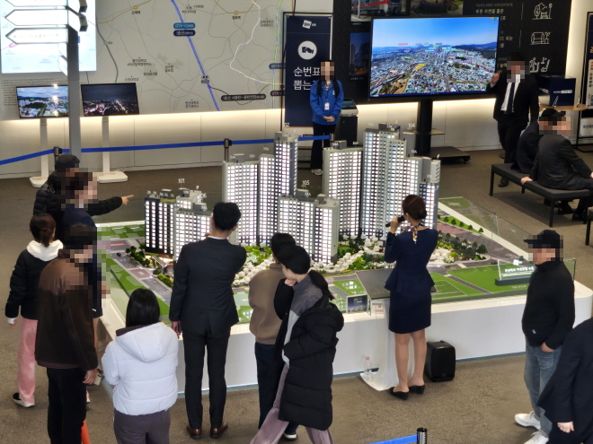 지난주 금요일 경기 수원시 장안구 영화동 인근에 개관한 두산건설의 '두산위브 더센트럴 수원' 견본주택 내부에서 방문객들이 모형도를 확인하고 있다./한국금융신문 조범형 기자