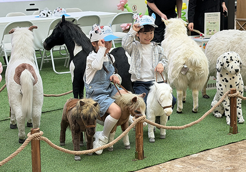 ▲ 농협경제지주 축산경제가 16일 스타필드 하남점에 오픈한 '도심 속 리얼 낙농목장' 팝업스토어에서 어린이 방문객들이 조랑말 모형을 타며 포즈를 취하고 있다.