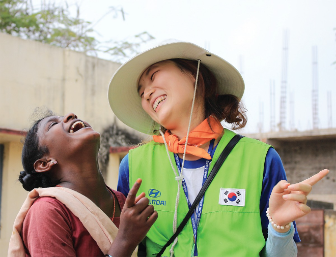 해피무브 봉사단에 참여한 자원봉사자가 현지 여성과 대화를 나누며 환하게 웃고 있다. 사진=현대자동차그룹