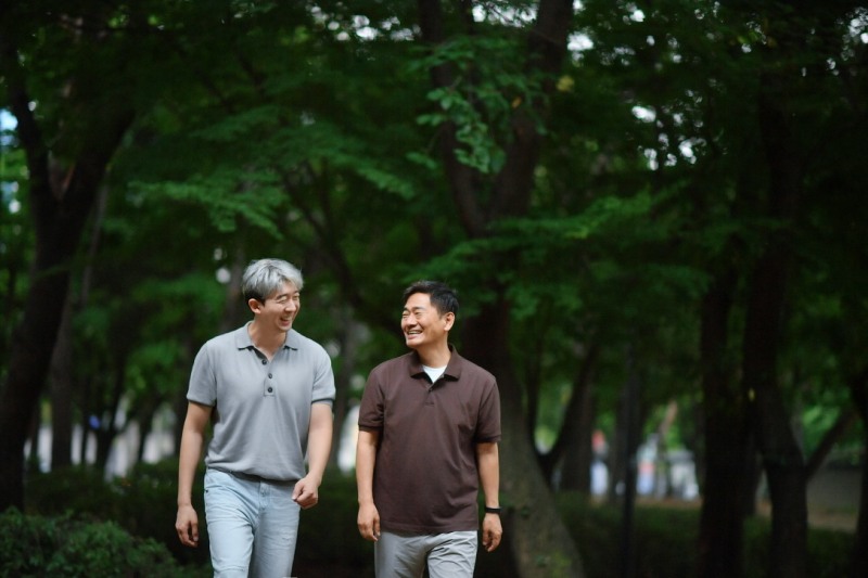 레벤북스의 새 책 '요즘 어때'를 같이 쓴 에드윈 킴 피아니스트와 이서원 심리상담가(사진 왼쪽부터)가 숲길을 같이 걸으며 대화를 나누고 있다.