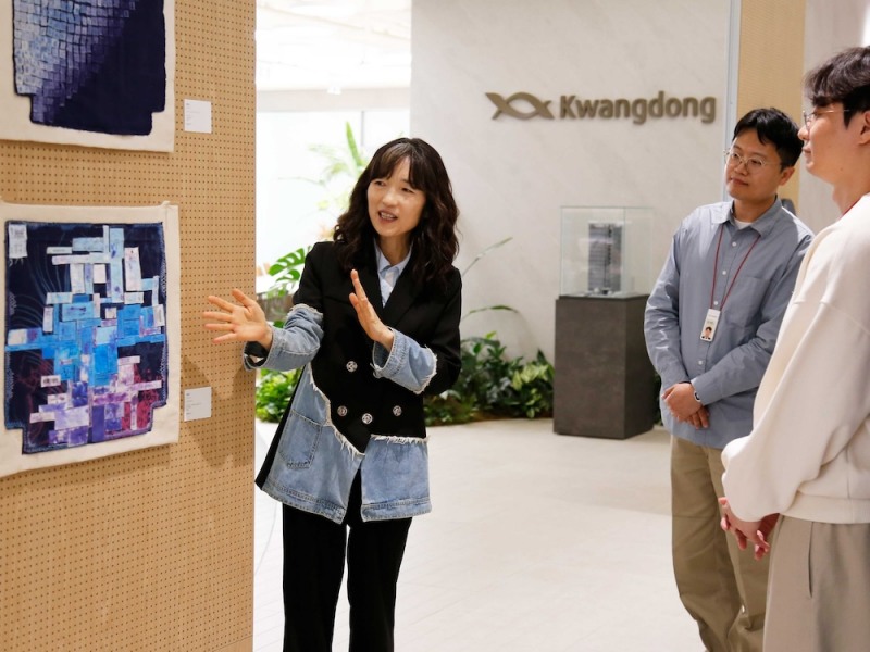 정은진 광동제약 정은진 ESG 위원장이 직원들에게 전시 작품을 설명하는 모습. /사진=광동제약