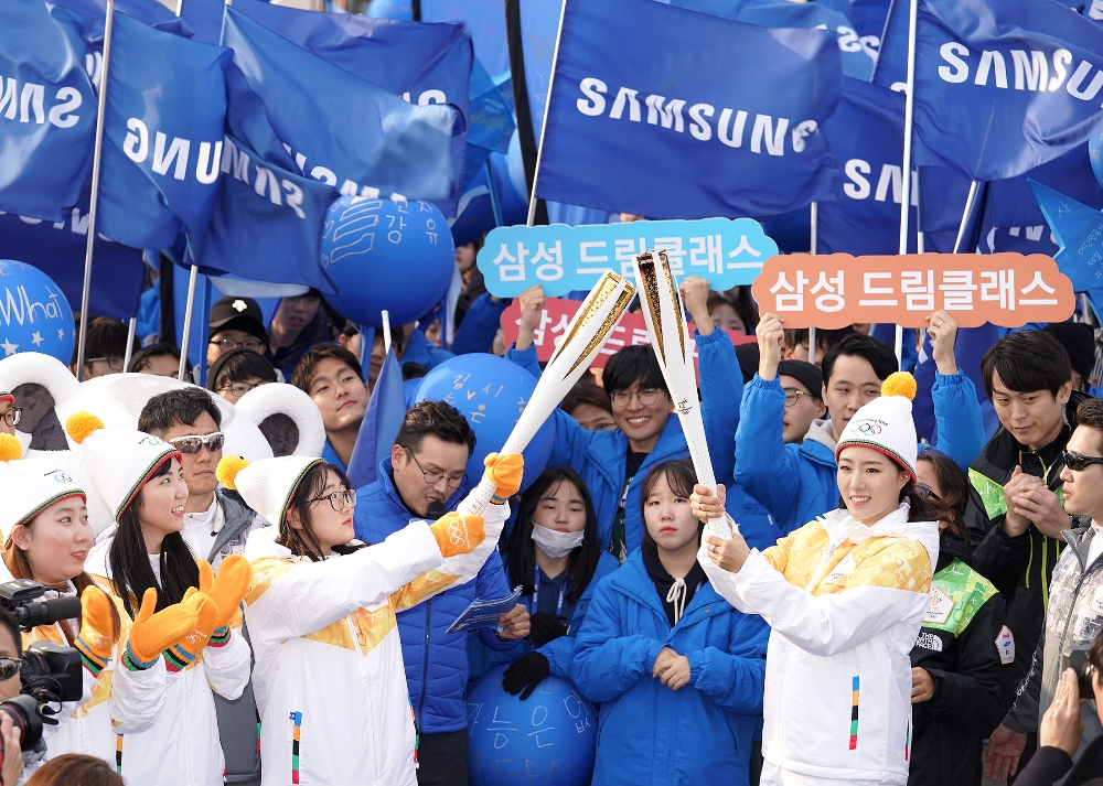 △1일 인천대교에서 진행된 성화봉송 현장에서 삼성 성화주자 이상화 선수가 삼성드림클래스 학생에게 희망과 열정을 상징하는 성화 불꽃을 전달하고 있다