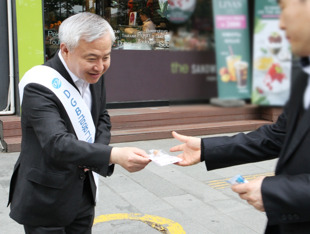 ▲김경규 하이투자증권 김경규 사장이 25일 오전 서울 여의도역 인근 지역에서 출근길 시민들에게 씨드볼을 전달하고 있다./사진=하이투자증권
