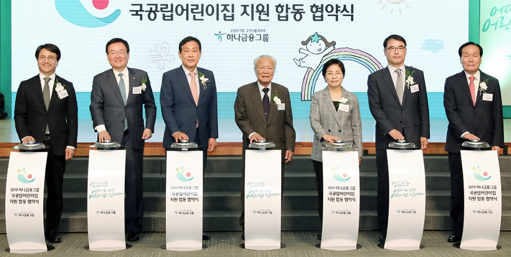 하나금융그룹은 9일 서울 중구 을지로 하나금융그룹 사옥에서 국공립어린이집 지원사업 대상지로 선정된 23개 지자체와 국공립어린이집 지원을 위한 합동 업무협약을 체결했다. 김정태 하나금융그룹 회장(사진 왼쪽에서 세번째), 박승 하나금융그룹 사회공헌위원회 위원장(사진 왼쪽에서 네번째), 이재현 인천 서구청장(사진 맨 왠쪽), 문인 광주 북구청장(사진 왼쪽에서 두번째), 김미경 서울 은평구청장(사진 왼쪽에서 다섯번째), 장충남 경남 남해군수(사진 왼쪽에서 여섯번째), 김주수 경북 의성군수(사진 왼쪽에서 일곱번째)이 함께 기념 세레모니를 하고 있다. / 사진= 하나금융지주