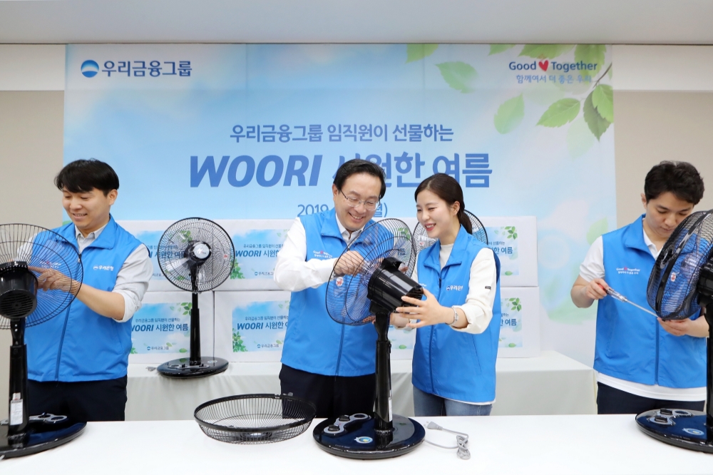 손태승 우리금융그룹 회장 겸 은행장(왼쪽 두번째)이 임직원들과 독거 어르신들의 폭염 피해 예방을 위해 사용될 선풍기를 직접 제작하고 있다./사진=우리금융그룹