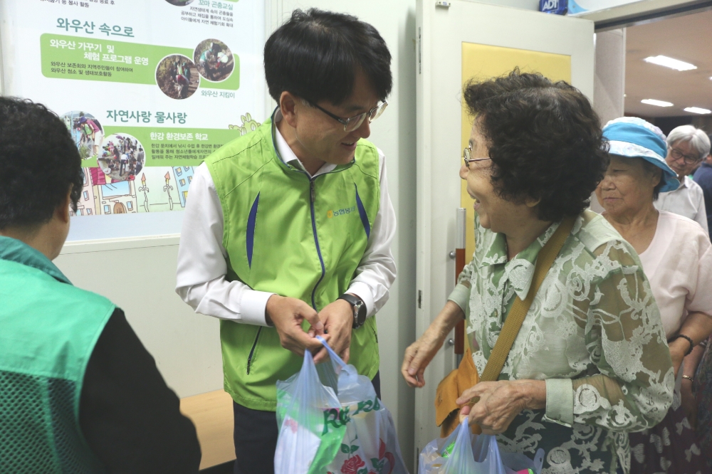 7일 마포구 서강동 주민센터에서 진행된 '건강한 여름나기 삼계탕 나눔 행사'에서 손병환 농협금융 사업전략부문장(상무)(왼쪽 두번째)이 지역 어르신에게 삼계탕을 나누어 드리고 있다./사진=NH농협금융지주