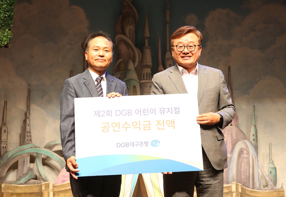 남재수 대구서문복지재단 관장(왼쪽) 임성훈 대구은행 상무가 공연수익금 전달 후 기념촬영을 하고 있다./사진=대구은행